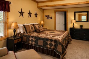 Une chambre à coucher avec un lit, des tables de chevet, une commode et une porte.