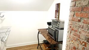A kitchen area with a microwave, oven, and a coffee machine on a countertop.