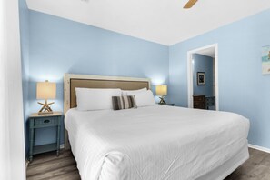 Ein Schlafzimmer mit einem großen Bett, zwei Nachttischen und einem Beistelltisch.