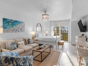 Ein modernes Hotelzimmer mit Bett, Sofa, Couchtisch und einem Essbereich.
