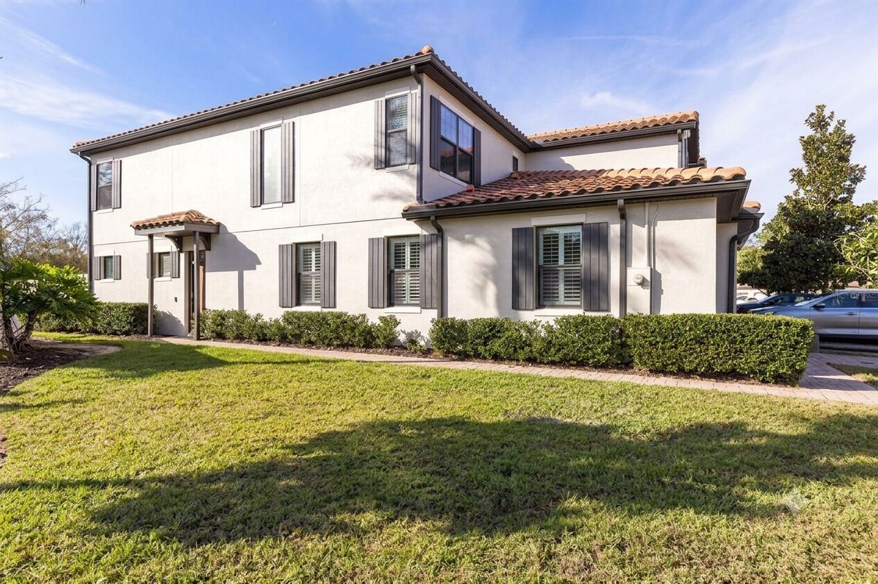 A two-story building with a flat roof, a front entrance with a door, and a small porch area.