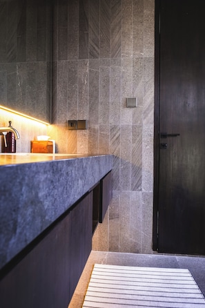 Ein modernes Badezimmer mit Marmorplatte, einer Handseifen-Spender und einem Handtuchspender.