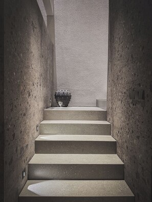 Betonstufen führen zu einer Wand mit strukturierter Oberfläche.