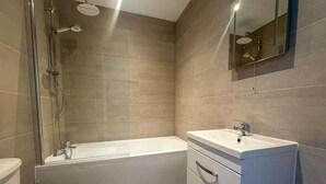Ein modernes Badezimmer mit Badewanne, Toilette und Waschtisch.