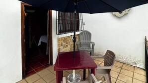 An outdoor patio with a table and chairs, a large umbrella, and a tiled floor. - La Posada de Don Manuel Hotel, Restaurante y Spa (Santiago Sacatepéquez)