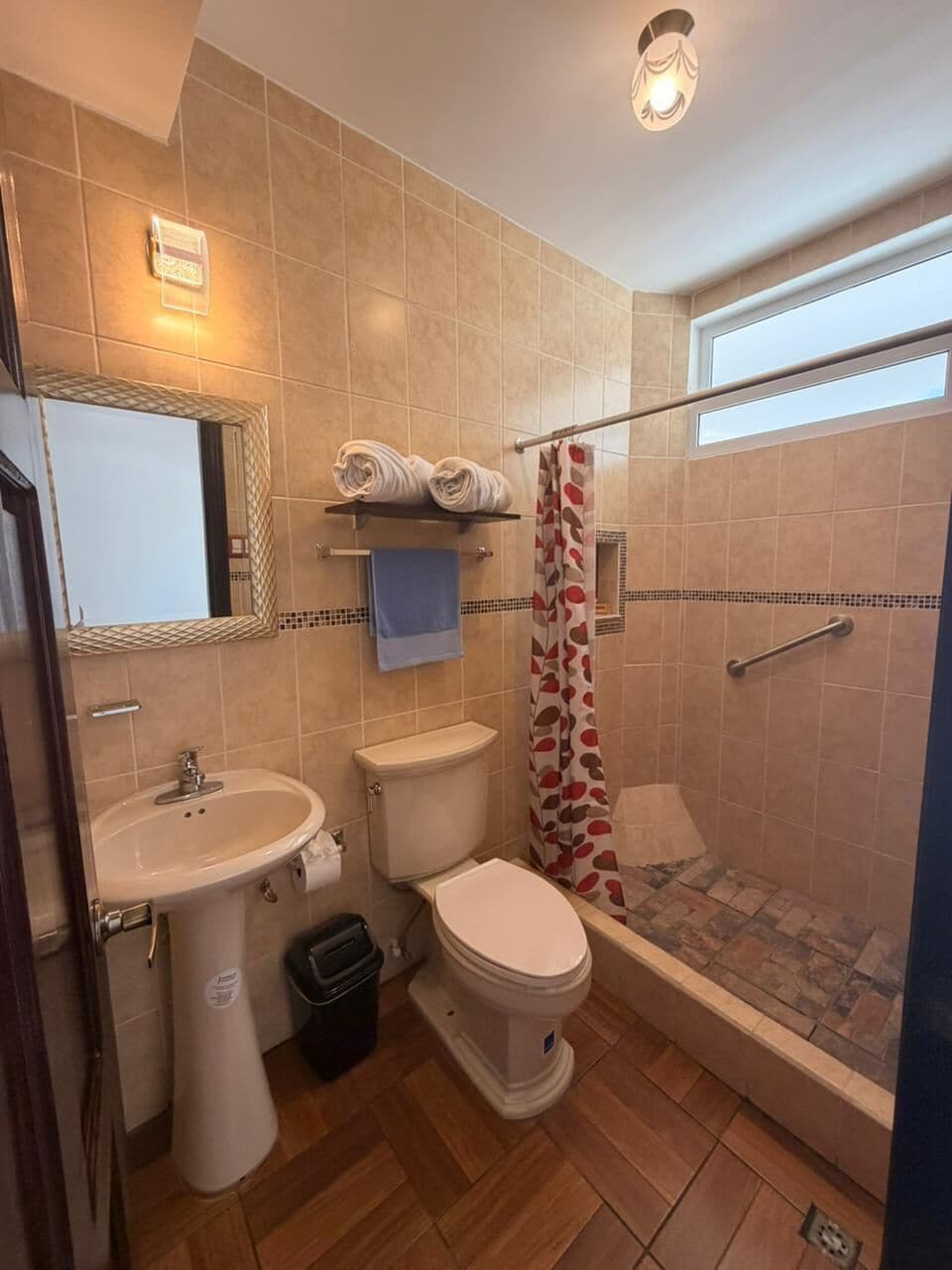 Ein Badezimmer mit Waschbecken, zwei Toiletten, einer Dusche und einem Spiegel.