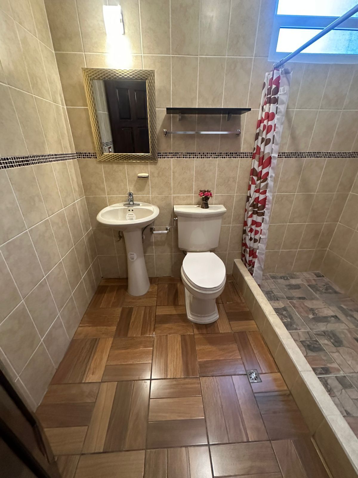 Un baño con inodoro, lavamanos y ducha.
