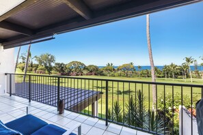 Ein Balkon mit Blick auf einen Golfplatz und das Meer.