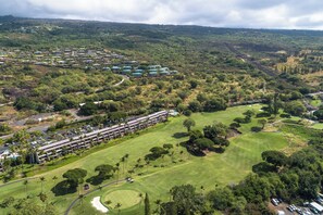 Ein Golfplatz mit einem Hotel im Hintergrund.