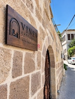 A sign for 'VINEV CAPPADOCIA Boutique House' on a stone wall.