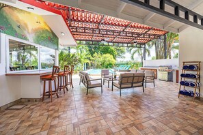 A covered outdoor seating area with a pool, bar, and grill. - Casa Vida Tropical / Your Private Oasis in the Heart of Jaco (Jacó)