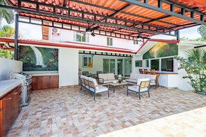 A covered outdoor area with a kitchen, seating, and a mural. - Casa Vida Tropical / Your Private Oasis in the Heart of Jaco (Jacó)