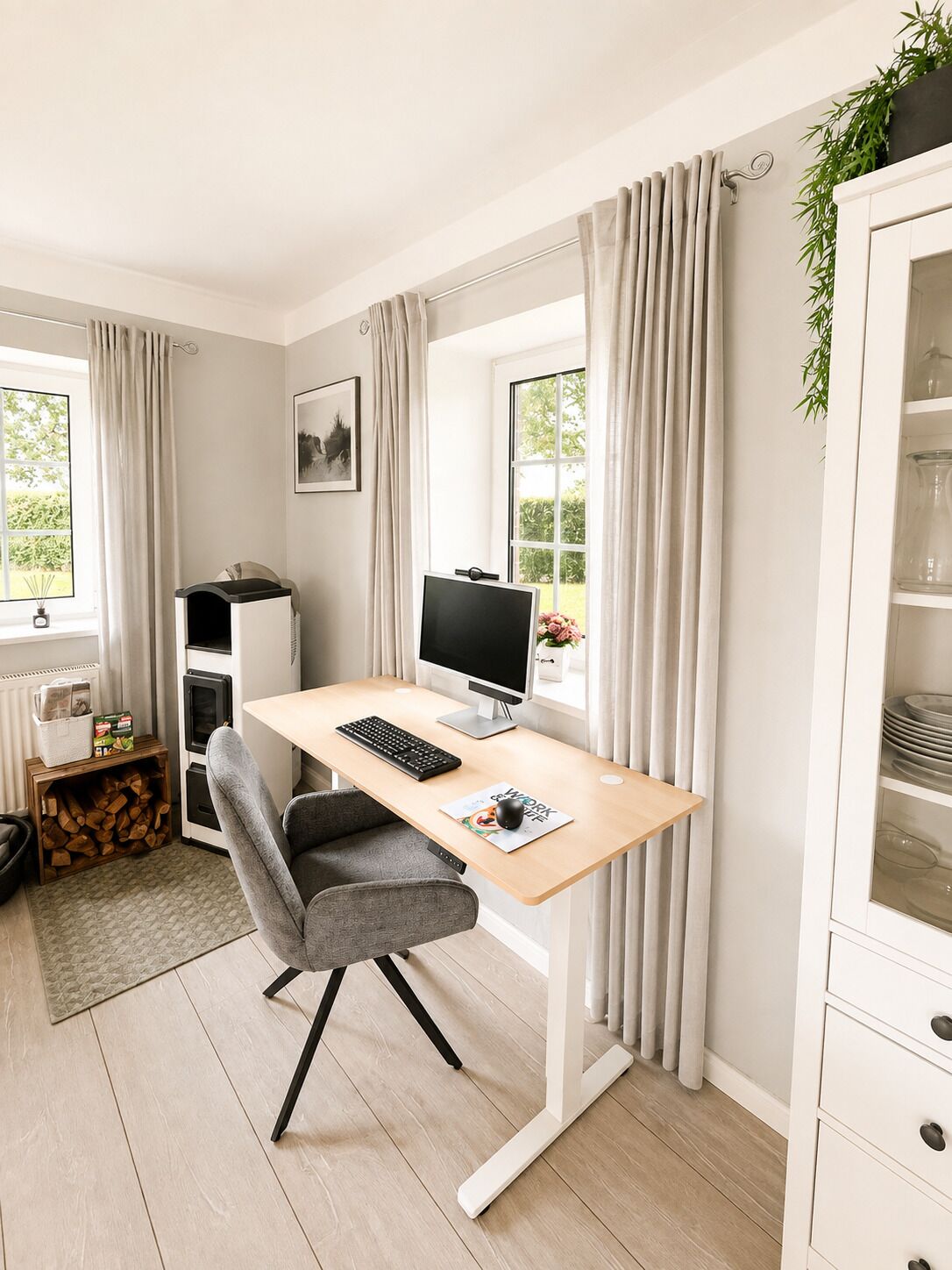 A modern office space with a desk, computer, chair, and a window with curtains.