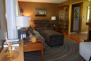 A cozy living room with a sofa, a coffee table, and a lamp.