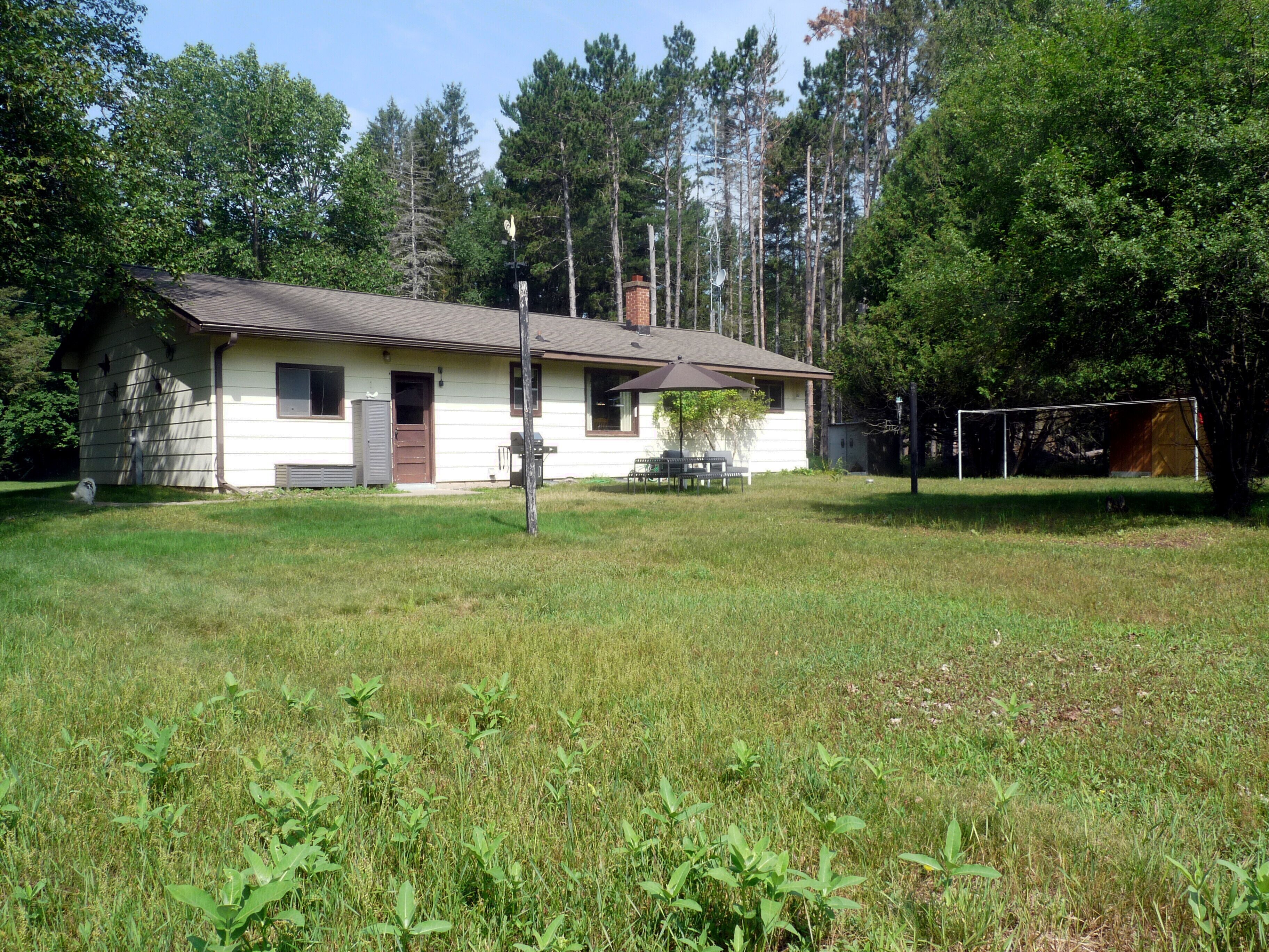 A single-story house with a front porch, a small patio, and a fenced yard.