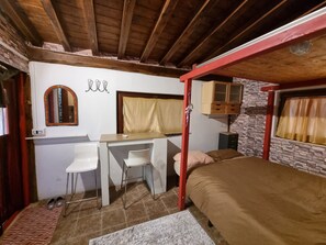 Ein Schlafzimmer mit Etagenbett, Schreibtisch, Stuhl, Spiegel und Kleiderschrank.