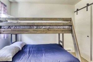 A bunk bed with a wooden frame, a blue mattress, and a white pillow. - Cozy South Lake Tahoe Cabin | Near Beaches, Mountain Bike Trails & Heavenly (South Lake Tahoe)