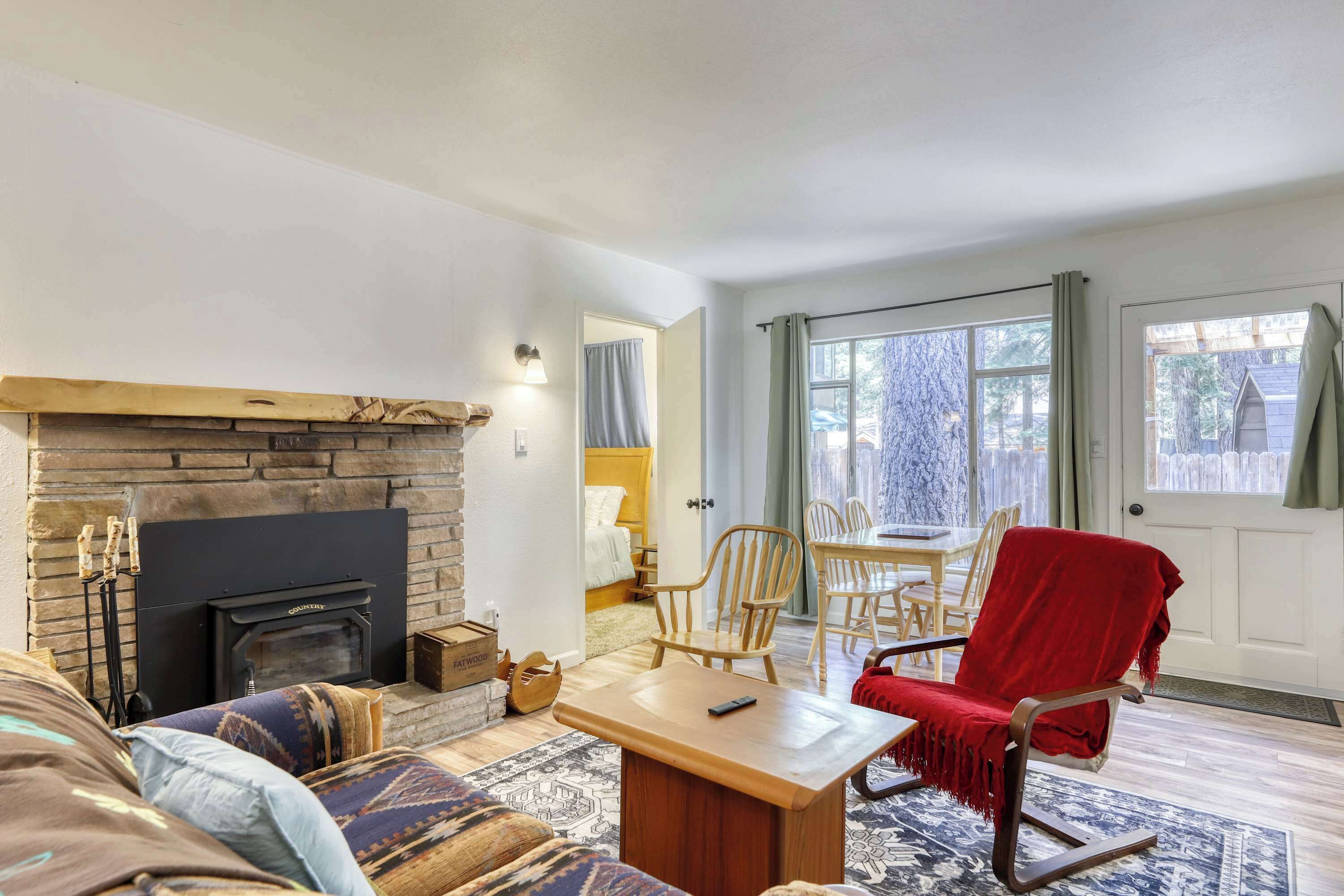 A cozy living room with a fireplace, a dining area, and a view of the outdoors.