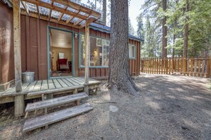 A cabin with a wooden deck, a covered porch, and a view of the surrounding forest. - Cozy South Lake Tahoe Cabin | Near Beaches, Mountain Bike Trails & Heavenly (South Lake Tahoe)