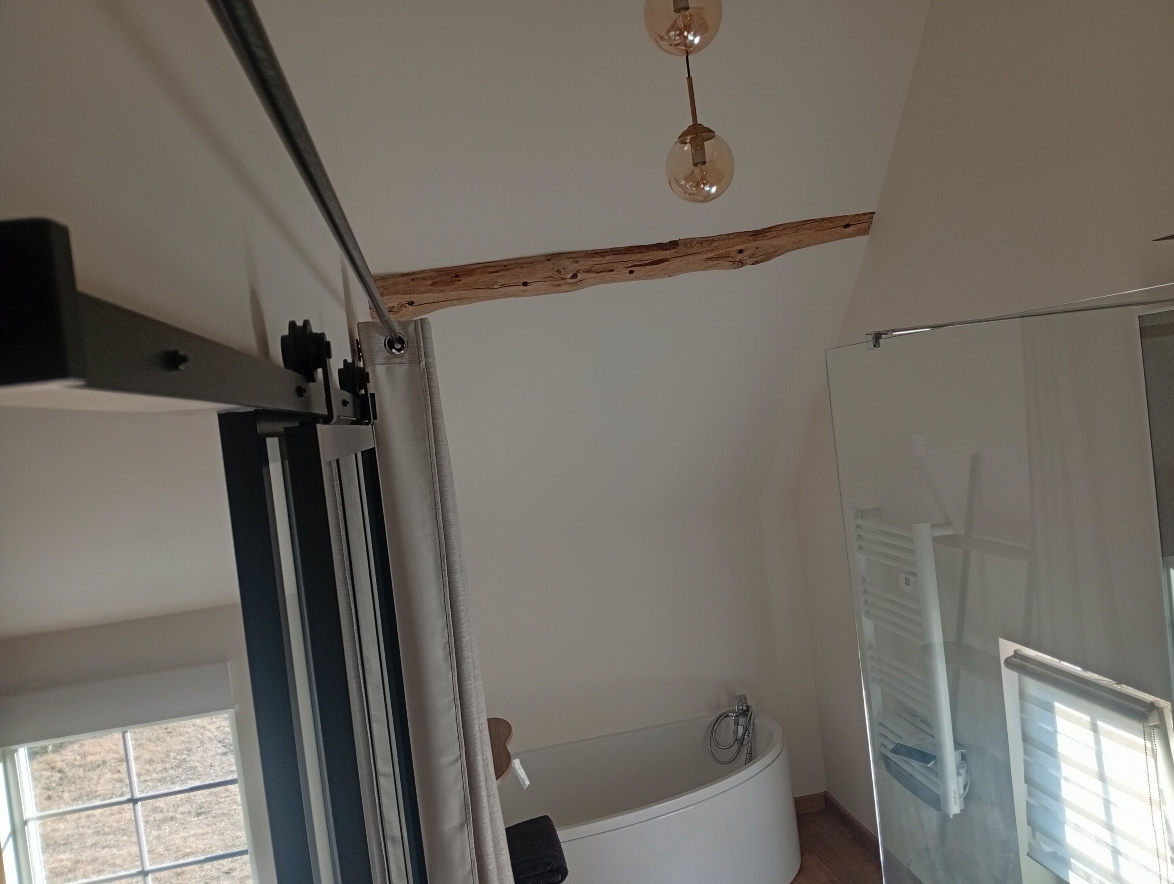A bathroom with a bathtub, a shower, and a window.