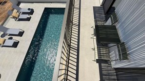A swimming pool with sun loungers and a metal railing. - Sunrise Village Aptera Private Pool Villa I (Souda)
