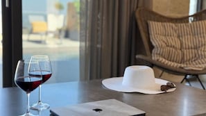 Ein Tisch mit zwei Weingläsern, einem weißen Hut und Sonnenbrille.