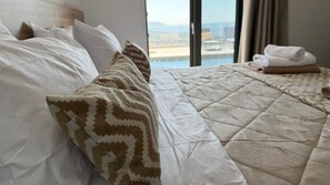 Habitación de hotel con cama, vista al mar y cortinas.