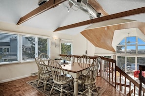 A dining area with a wooden table and chairs, large windows, and a view of the outdoors. - Marvelous 5-bedroom beachfront townhome in Ocean City (Ocean City)