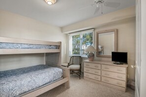 A bedroom with a bunk bed, a desk with a chair, a dresser, a television, and a window with blinds. - Marvelous 5-bedroom beachfront townhome in Ocean City (Ocean City)