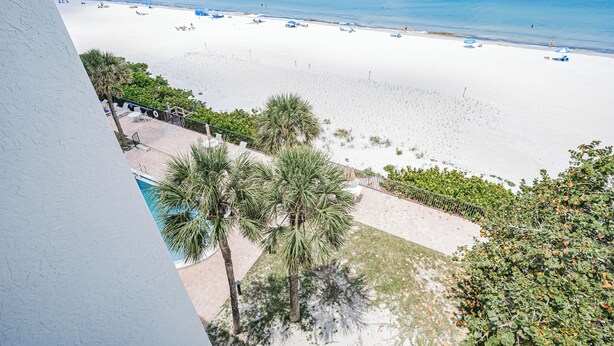 A beach view with a pool area and a white sandy beach. - Pelican Cove 505 - A Quiet Getaway Awaits (Indian Rocks Beach)
