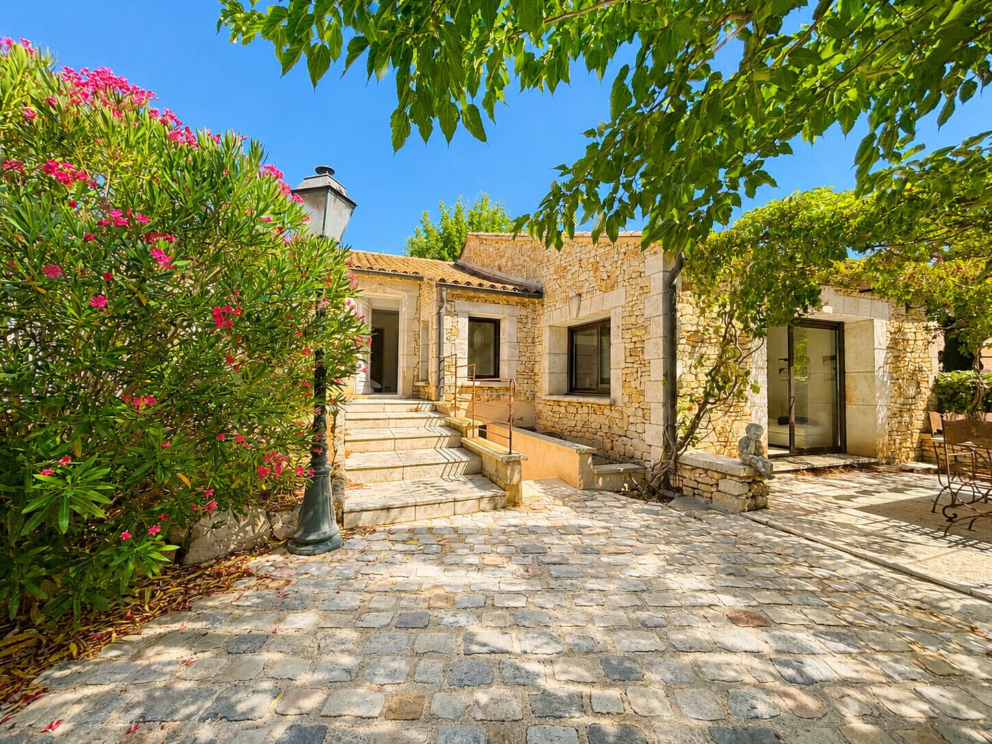A stone building with a courtyard, a staircase, and a door leading to a covered area.