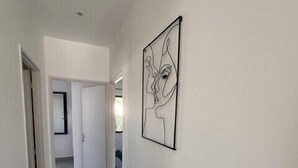 A hallway with a tiled floor and a framed artwork on the wall. - Olia - Private pool close to the city center (L'Isle-sur-la-Sorgue)