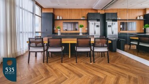 Una cocina moderna con armarios de madera, una isla central y una zona de comedor con sillas.