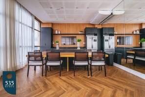 Eine moderne Küche mit Holzausstattung, einer zentralen Kochinsel und einem Essbereich mit Stühlen.