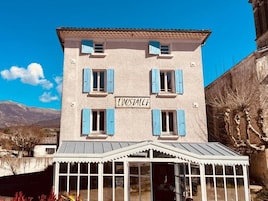 Un edificio con un letrero que dice 'LOUSTALET' y un acceso cubierto.