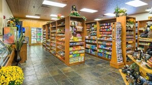 Een winkelinterieur met schappen vol diverse producten, een koelvitrine en een schoenenafdeling.