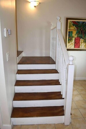 A staircase with white balusters and dark wooden steps. - Tangerine Sunsets Medina (Nassau)