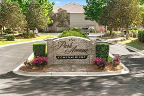 A residential area with a sign for '450 Park Avenue Condominiums' and a stop sign at the intersection. - Stunning 3BR, 2BA luxury retreat with pool view, just 7 miles from the beach! (Foley)
