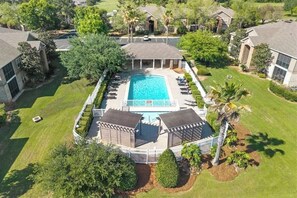 Ein Wohnhaus mit Pool, umzäunter Garten und umliegenden Häusern.