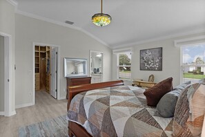 Ein Schlafzimmer mit Bett, Schminktisch, Spiegel und Blick ins Freie.