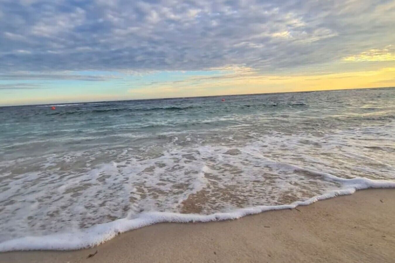 Une plage où les vagues viennent doucement lécher le rivage.