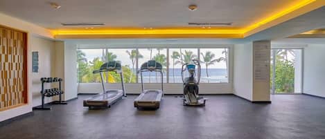 Une salle de sport équipée de tapis de course, d’un vélo d’appartement et d’un porte-haltères.