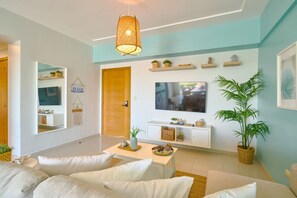 Un salon moderne comprenant un canapé, une table basse, un téléviseur et des objets décoratifs.