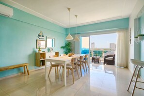 Ein modernes Wohnzimmer mit Essbereich, ein Balkon mit Aussicht und ein großes Fenster.