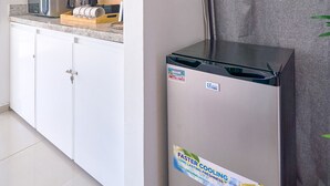 A kitchen with white cabinets, a microwave, a coffee maker, and a refrigerator with a sticker. - Caribbean BeachSide Apt Juan Dolio Beach Las Velas (Playa Juan Dolio)