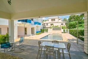 A modern outdoor pool area with a dining setup. - BeachsideGetaway|3BR|Pool|5Min walk to Beach|Wi-Fi (Juan Dolio)