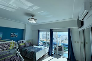 A hotel room with a balcony, a bed, a ceiling fan, and a view of the city. - BeachSide Blue Cleef Playa Juan Dolio Las Velas (Juan Dolio)