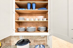 A kitchen cabinet with multiple shelves, some containing plates and cups. - Heated Saltwater Pool, Game Room&Mini Golf. Near Anna Maria Island & IMG Academy (Bradenton)