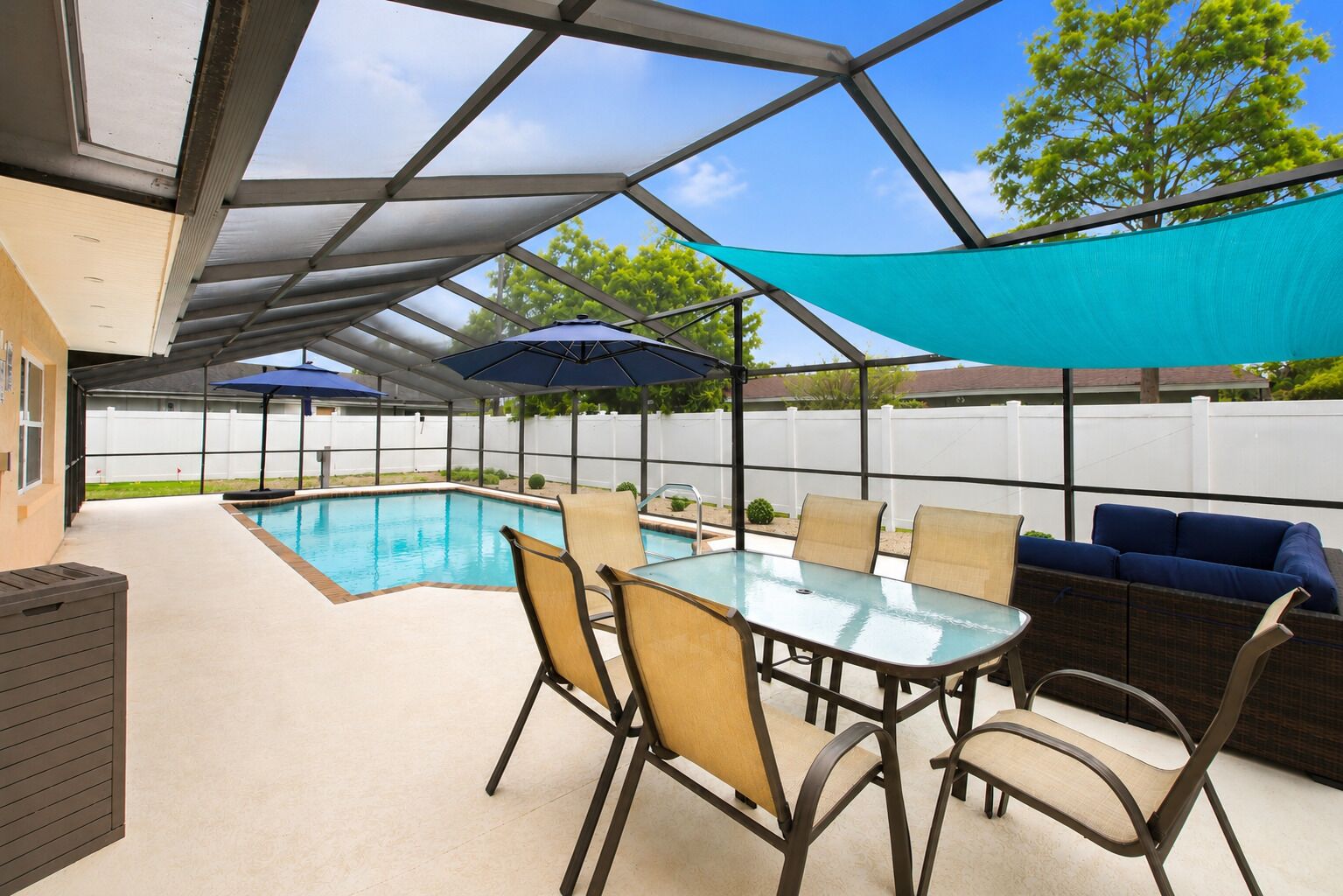 Eine Außenpatio mit Pool, Tisch, Stühlen und einer Sitzecke.