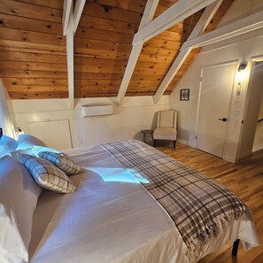 A bedroom with a wooden ceiling, a bed with a plaid blanket, a chair, and a door. - ​Peaceful 3BR Arnold Escape w/ Hot Tub, AC & Deck. Steps from Arnold Rim Trail (Arnold)